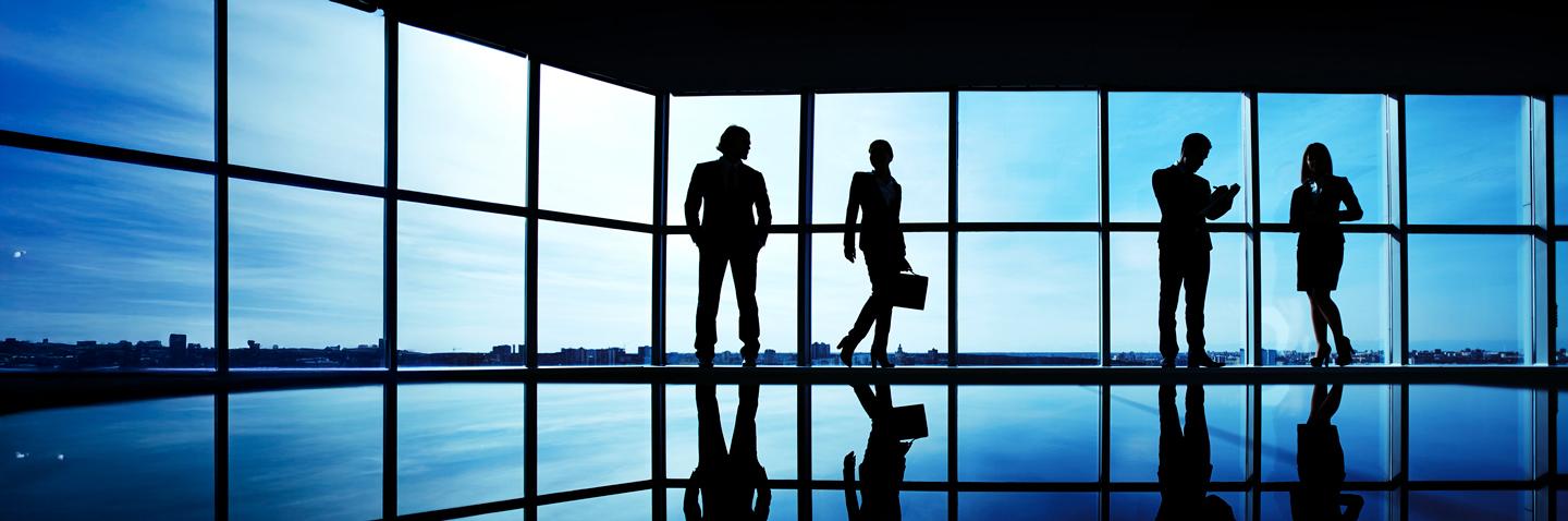 professionisti in penombra davanti una vetrata